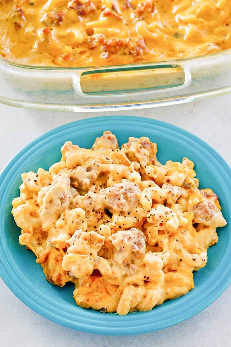 sausage mac and cheese casserole on a plate and in a baking dish.