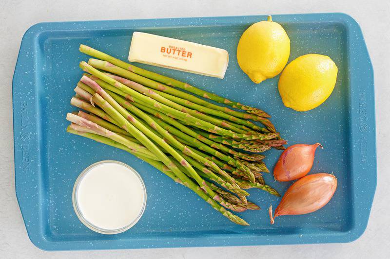 sauteed asparagus with lemon cream sauce ingredients on a tray.