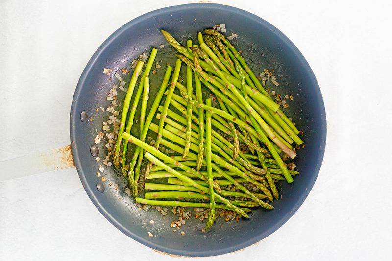 butter sauteed asparagus in a skillet.