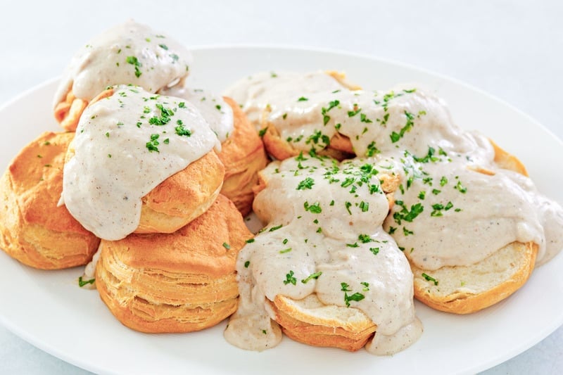 homemade white gravy and biscuits on a plate.