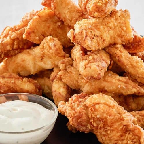 beer battered chicken strips piled on a platter.