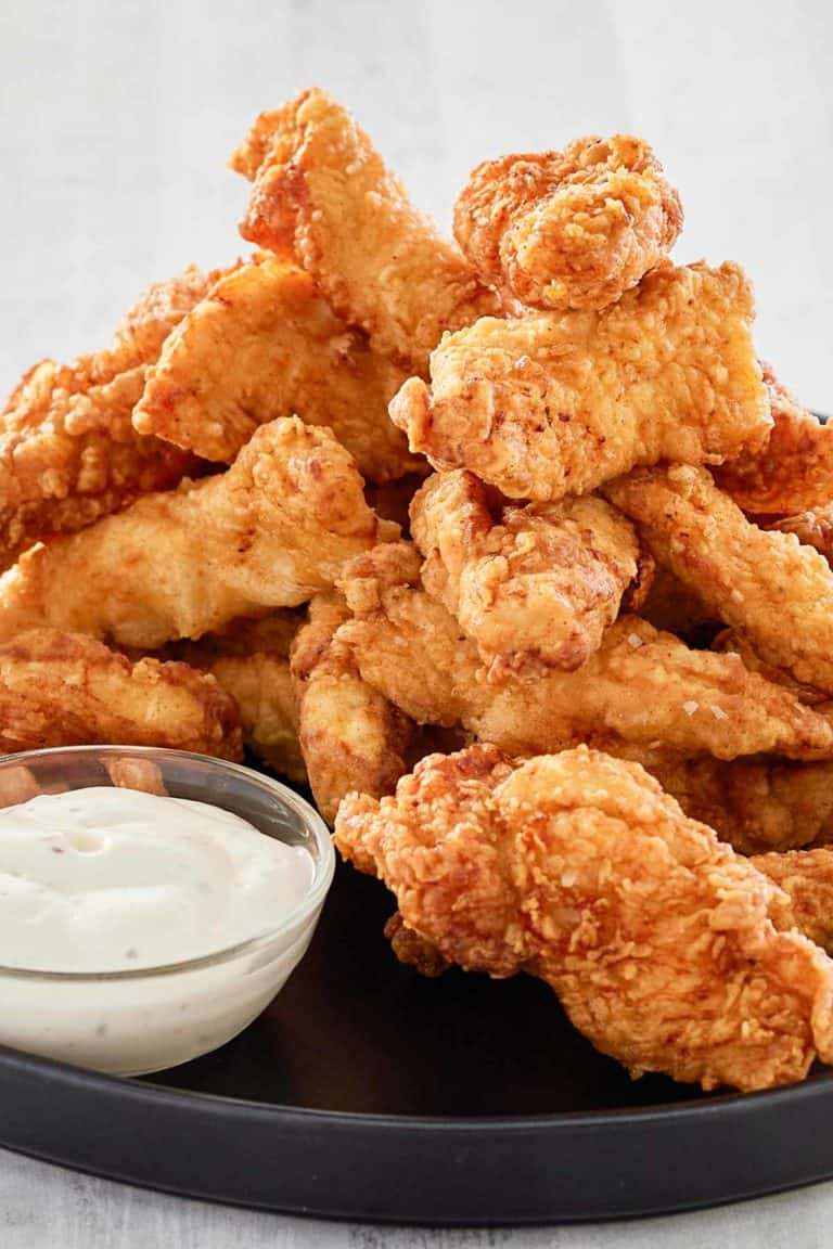 beer battered chicken strips piled on a platter.