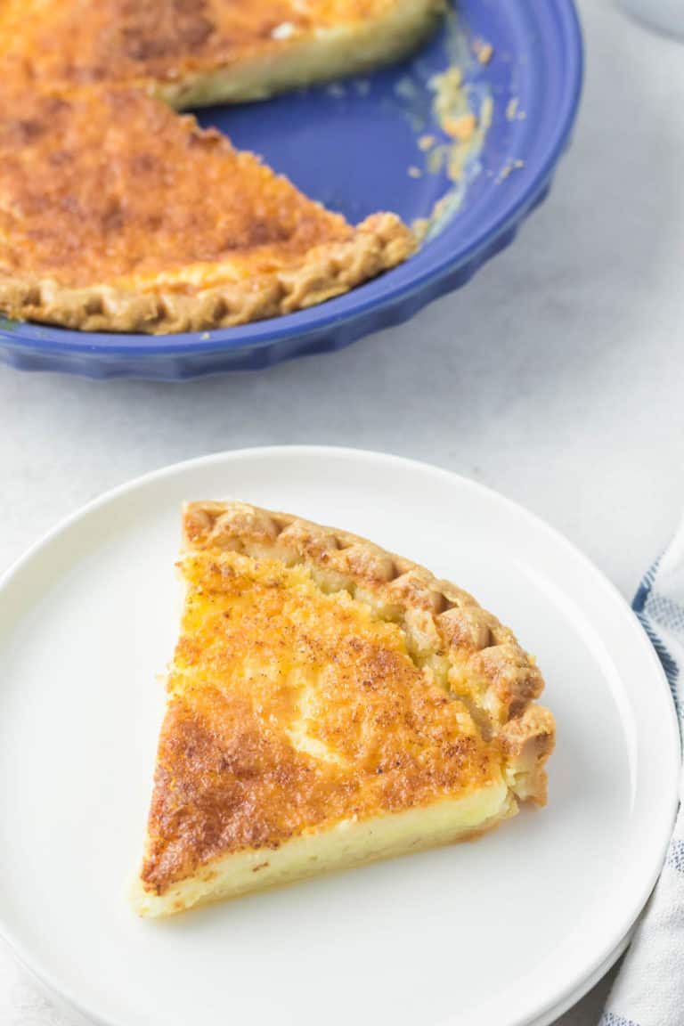 buttermilk pie slice on a plate next to the pie.