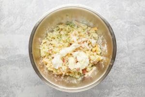 adding sour cream to loaded baked potato tots filling mixture.