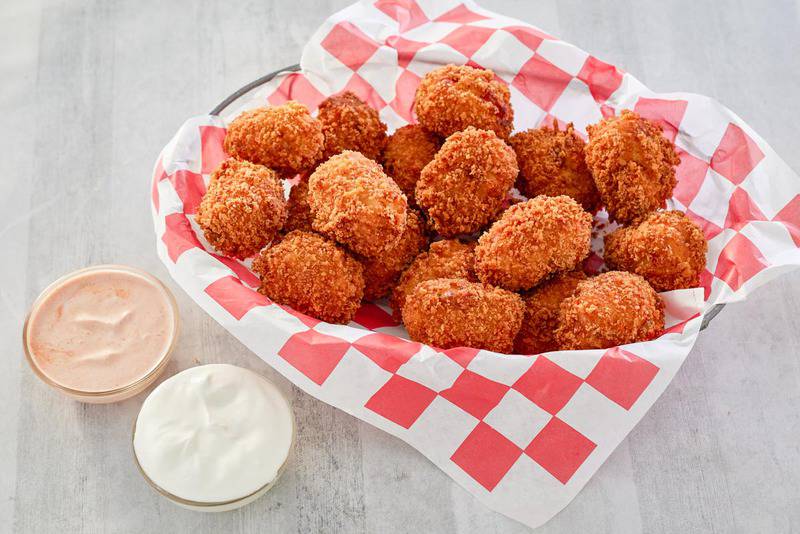 copycat Cheesecake Factory loaded baked potato tots and cups of dipping sauces.