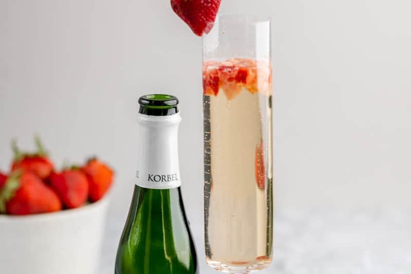 copycat Grand Lux Cafe Strawberry Bellini, Champagne bottle, and strawberries.