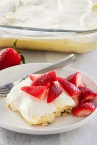 lemon lush topped with strawberries on a plate.