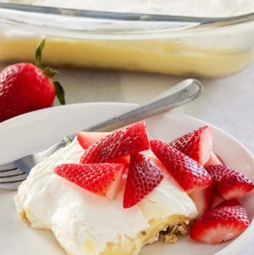 lemon lush topped with strawberries on a plate.