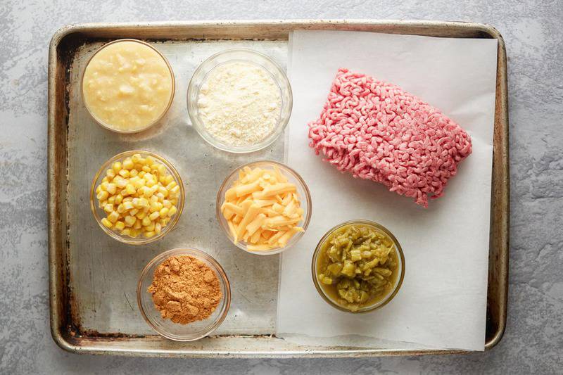 Mexican cornbread casserole ingredients on a baking sheet.