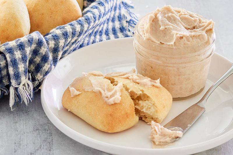 homemade Texas Roadhouse honey cinnamon butter in a jar and on a roll.