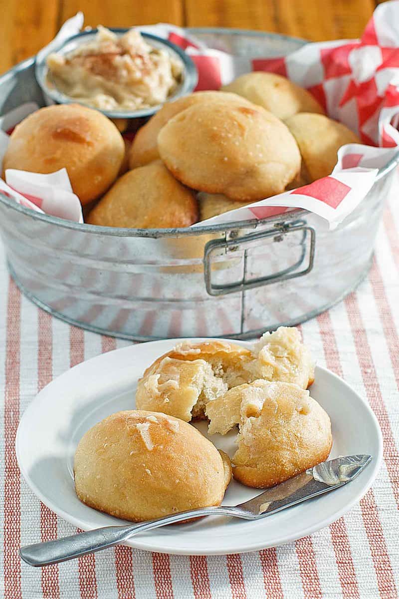 copycat Texas Roadhouse rolls in a metal tub and on a plate.