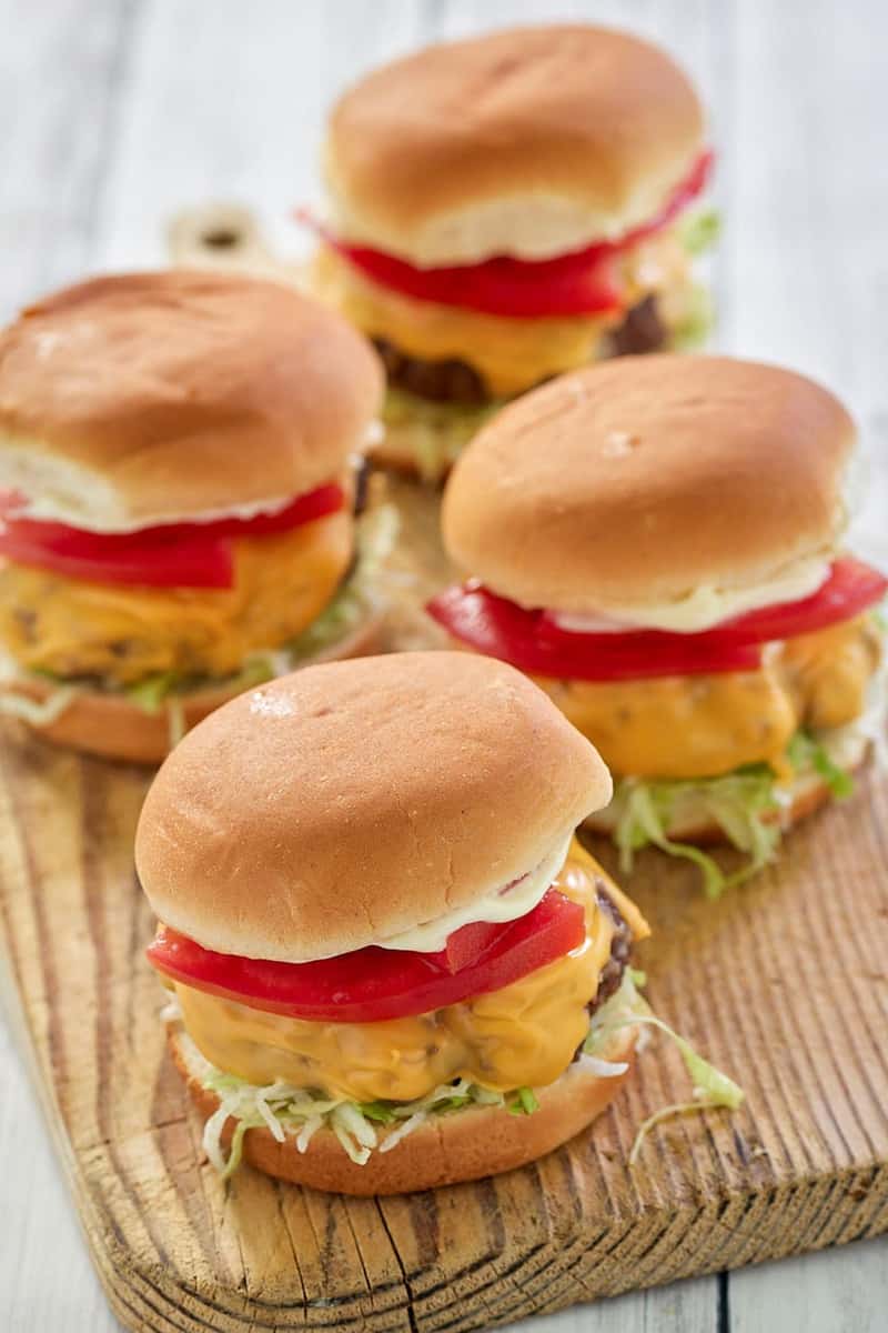 air fryer hamburgers with cheese on a wood board.