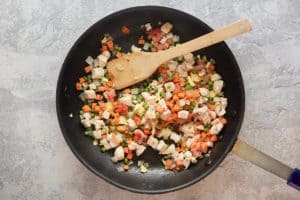 chicken pieces and chopped vegetables in a skillet.