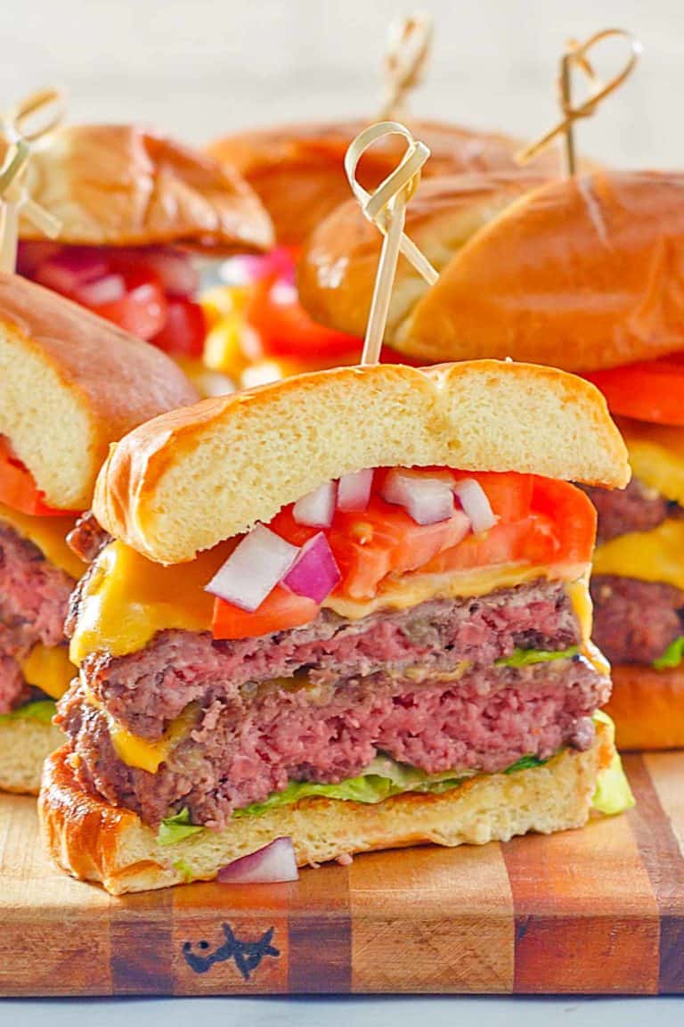 homemade double garlic burger with cheese, lettuce, tomato, and onion.
