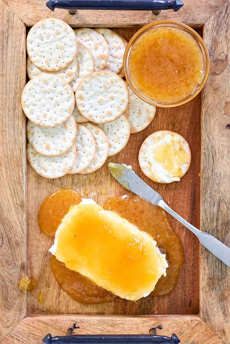 overhead view of jezebel sauce over cream cheese and crackers on a tray.