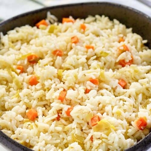 homemade rice pilaf in a black bowl and a spoon.