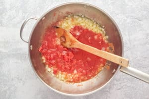 tomatoes and sauteed onions in a pan.