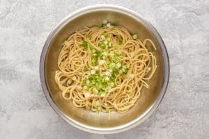 noodles and green onions in a bowl.