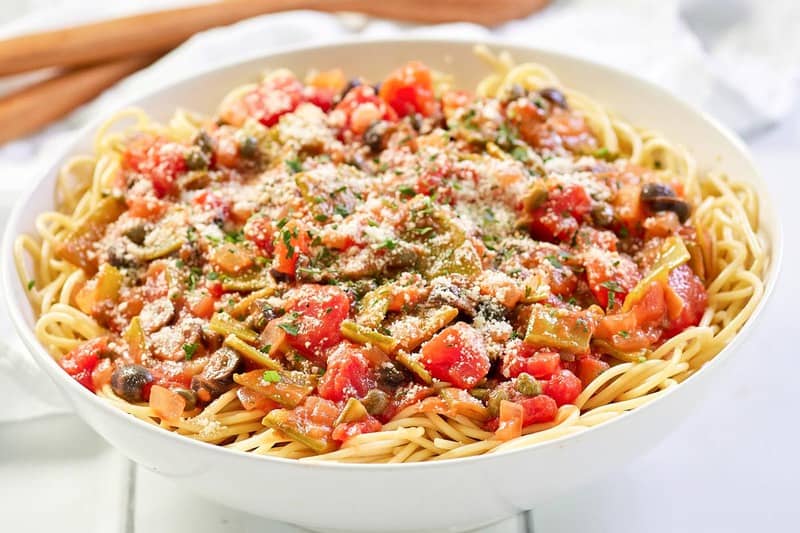 spaghetti alla puttanesca in a white pasta dish.