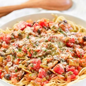 spaghetti alla puttanesca and wood serving spoons.