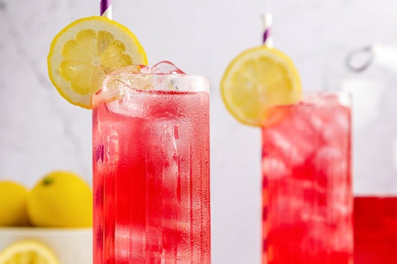 two copycat Starbucks passion tea lemonade drinks garnished with lemon.