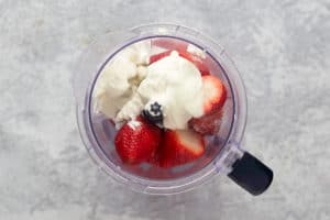 strawberries, sugar, and yogurt in a blender.