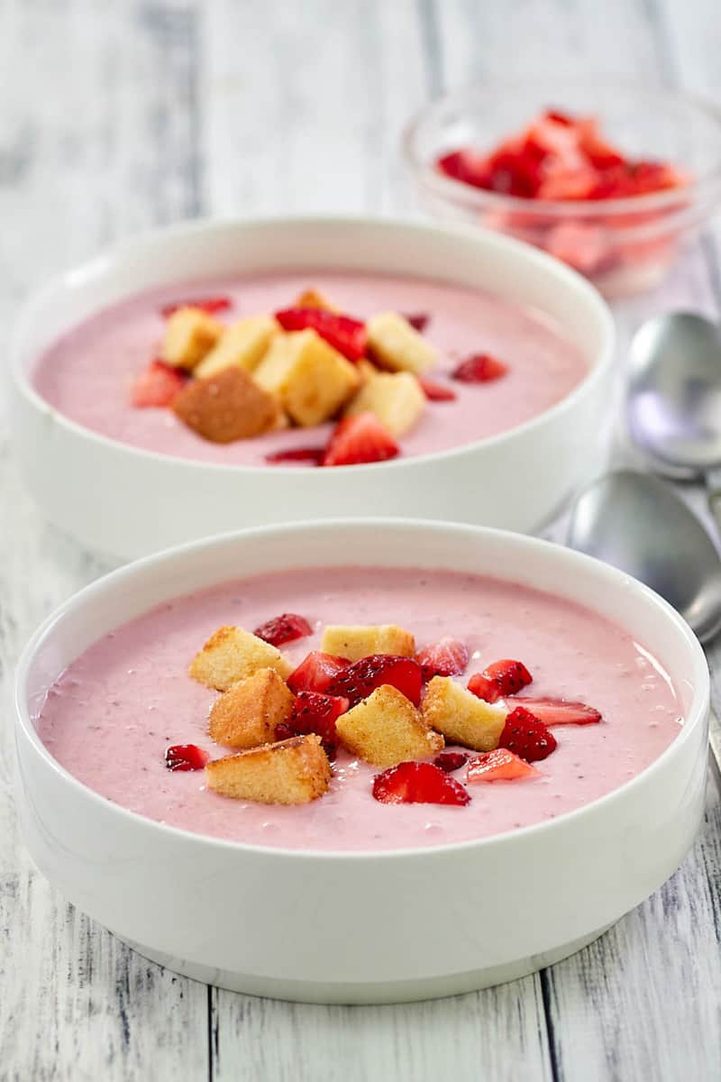 bowls of chilled strawberry soup with pound cake croutons and chopped strawberries.