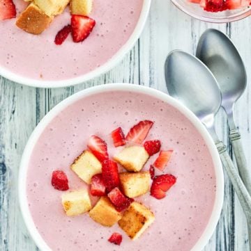 overhead view of strawberry soup with pound cake croutons.