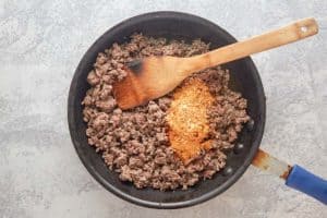 browned ground beef and Taco Bell meat seasoning in a skillet.