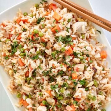 overhead view of Thai chicken fried rice and chopsticks on a platter.