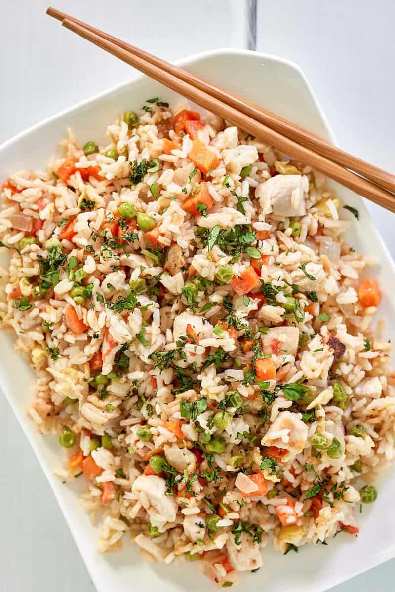 overhead view of Thai chicken fried rice and chopsticks on a platter.