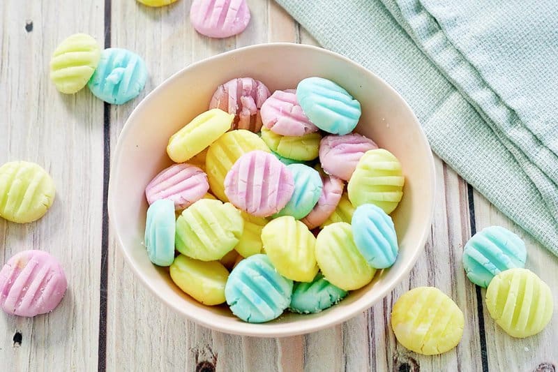 pastel colored homemade cream cheese mints in a bowl.