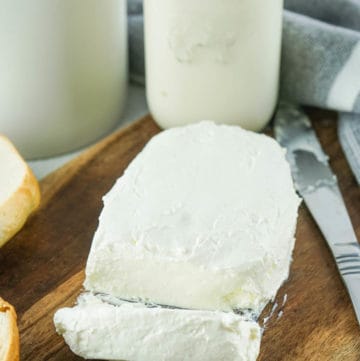 block of homemade cream cheese and a glass bottle of half and half.