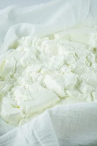 homemade cream cheese on cheesecloth before draining.