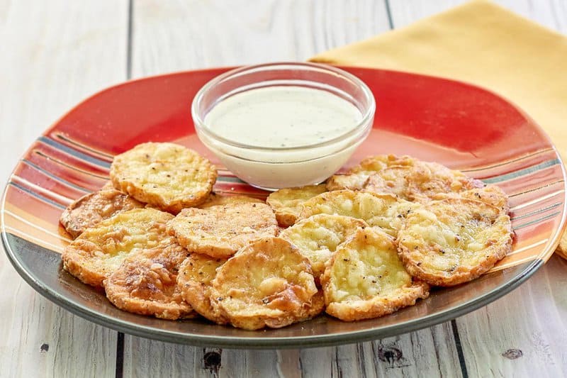 mojo potatoes and a bowl of dipping sauce on a plate.