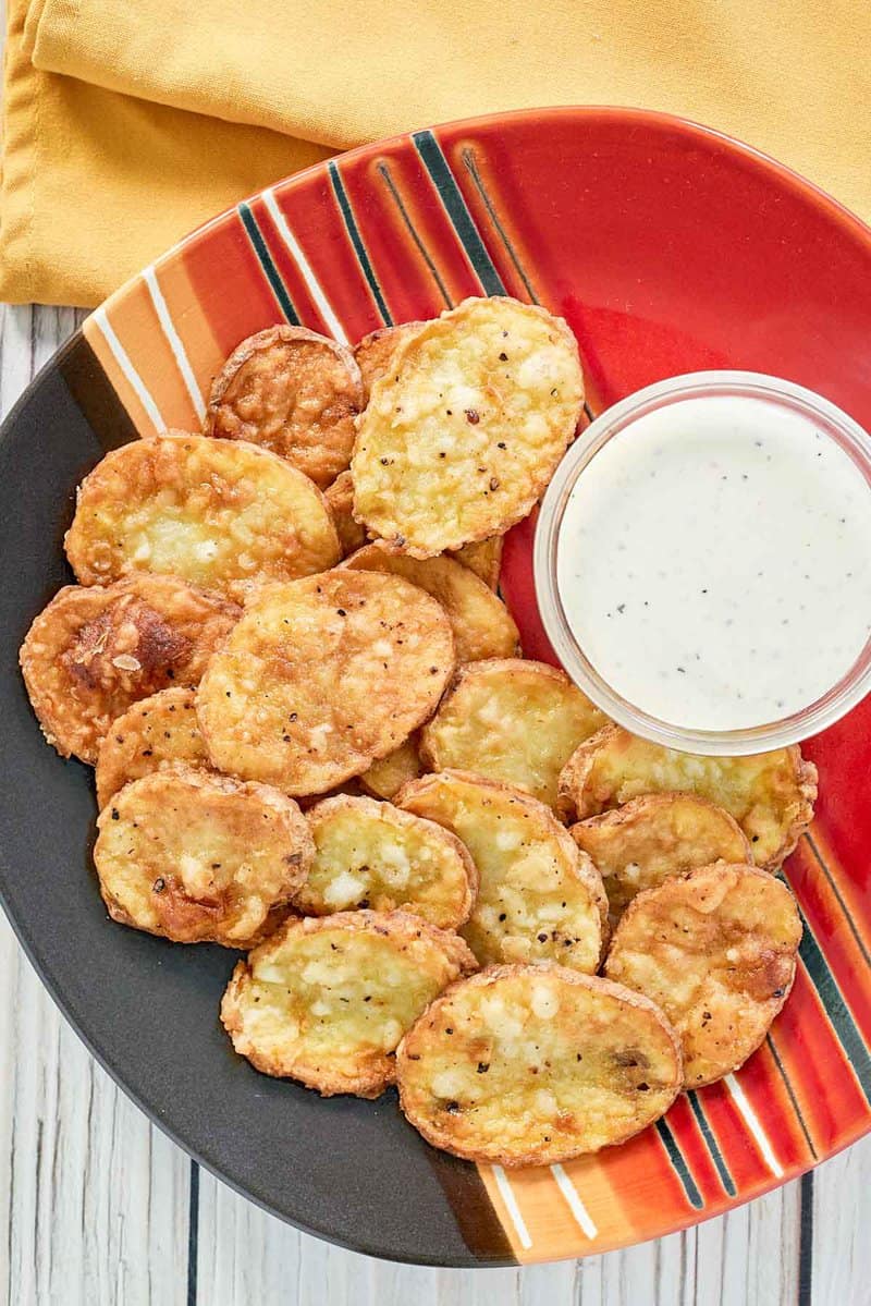 overhead view of mojo potatoes and dipping sauce on a platter.