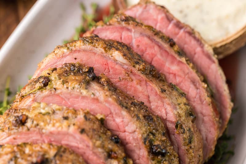 closeup of smoked eye of round roast slices on a platter.