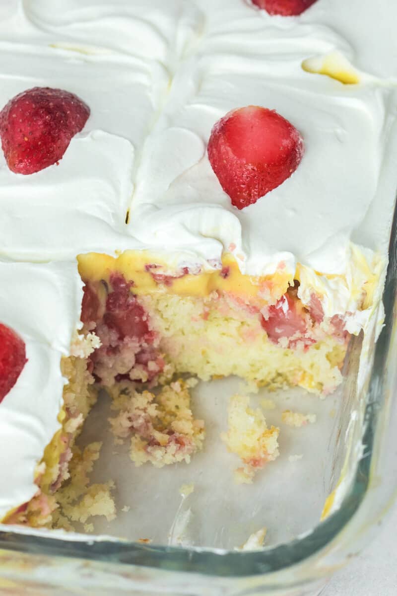 strawberry poke cake in a glass baking dish.