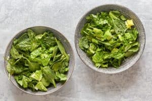 romaine lettuce and spinach in two bowls.