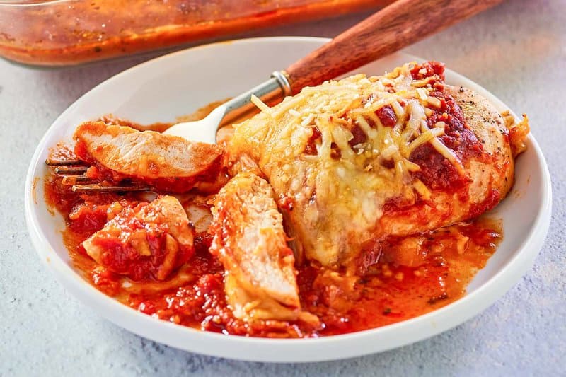 a serving of baked chicken parmesan on a plate.