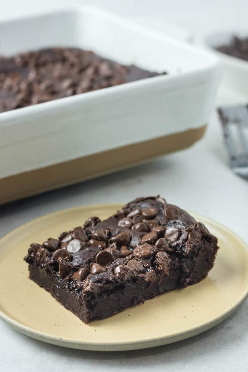 chocolate pudding slice on a plate in front of the cake.