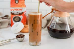 stirring a homemade Dunkin Donuts butter pecan iced coffee drink.