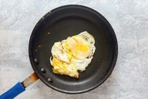 fried egg with broken egg yolk in a skillet.