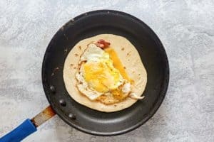 copycat Dunkin wake up wrap cooking in a skillet.