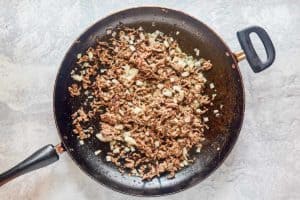 browned ground beef and onions in a skillet.