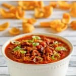 bowl of Instant Pot Wendy's chili and corn chips scattered behind it.