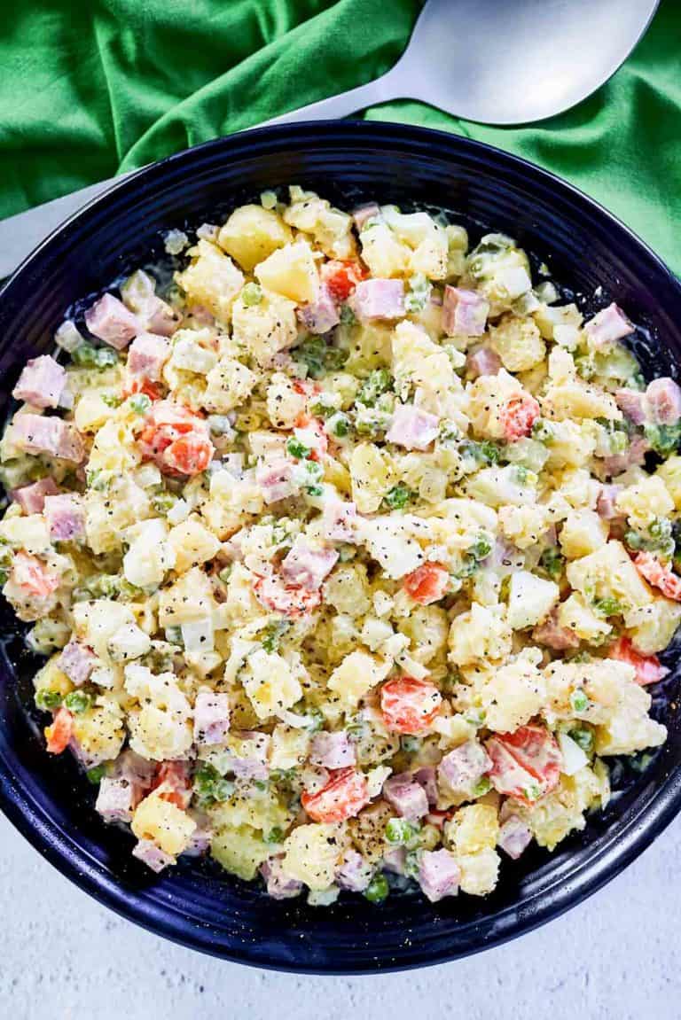 overhead view of olivier salad in a black serving bowl.