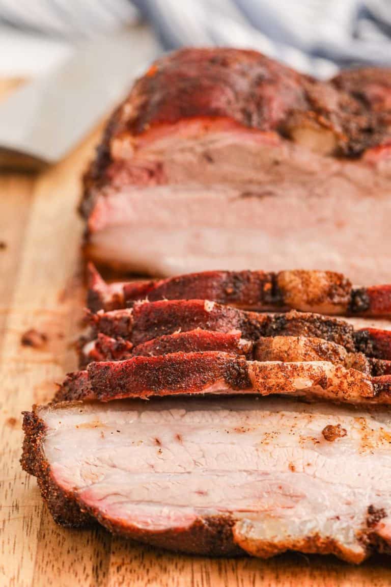 close up of smoked pork belly on a cutting board.