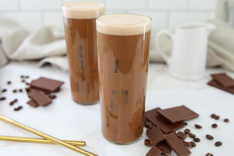 two copycat Starbucks chocolate cream cold brew drinks and chocolate pieces.