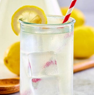 copycat Chick Fil A lemonade in a glass and pitcher.